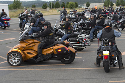 Group of riders gather in a parking lot.