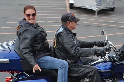 Man and woman on a blue motorcycle.