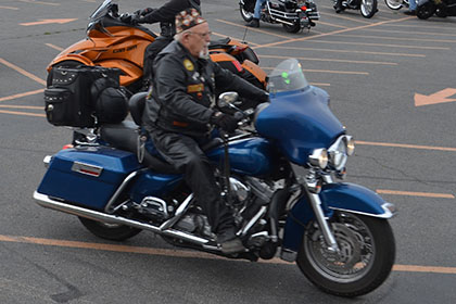Riders with their motorcycles in the parking lot.