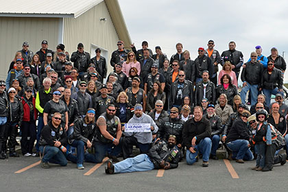 Large group of riders pose for group photo.