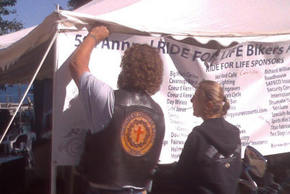 Volunteers put up a Ride for Life banner at the event.