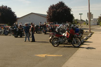 Motorcycles and people in parking lot before event.