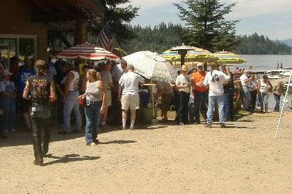 Crowd of people outside of a building at the event. Lake in the background.