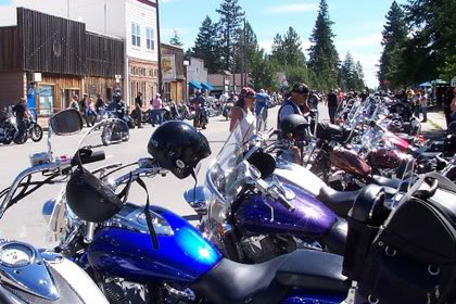 Motorcycles line both sides of the street.