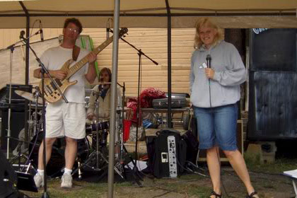 Live band poses under tent.