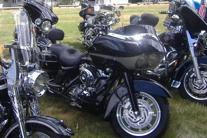 Close up shot of several motorcycles in parking area.
