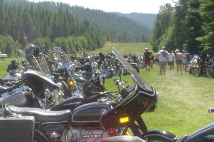 Long lines of motorcycles stretch into the distance with small planes in background.