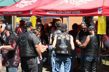 People line up outside of a tent.