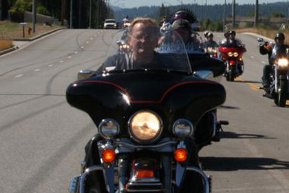 Two lines of motorcycles on highway driving towards camera.