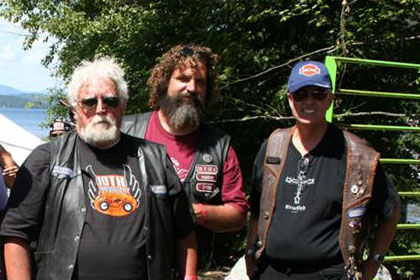 Group of people pose for camera outside of blue tent.