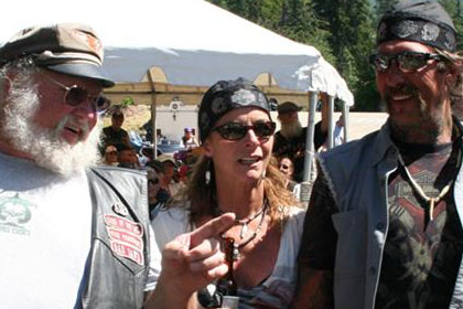 Two men and a woman talk and walk together at event.