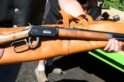 Man holds long rifle.