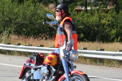 Man stopped in road with his motorcycle to help direct other riders.