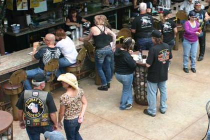 Crowds of people at event at and around bar.