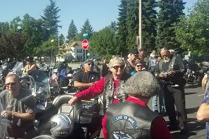 Riders standing next to their motorcycles.