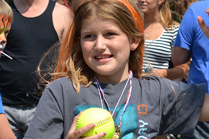 Young girl throws balls at the dunk tank.