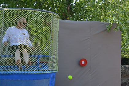 Children throwing balls at the dunk tank.