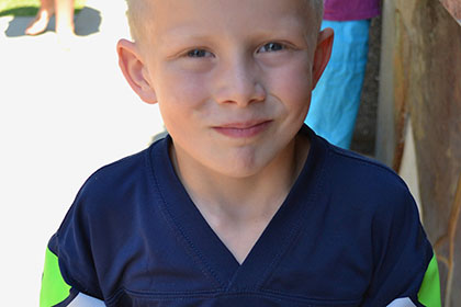 Child holding a plate full of food.