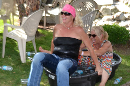 Two women fall into the tub full of ice water.