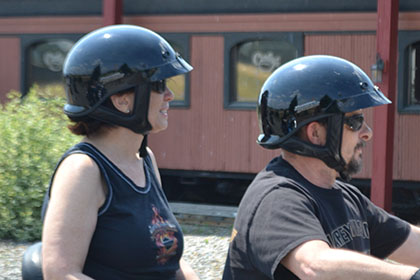 Riding on their motorcycle.