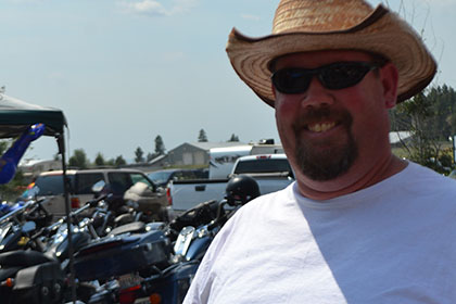 A happy man wearing sunglasses and a hat.
