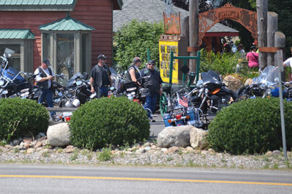 Guys in the parking lot next to motorcycles.