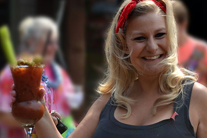 Smiling woman holds her drink up.