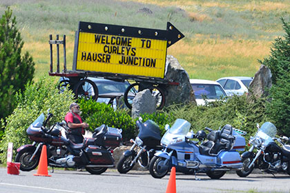 Man stands next to his parked motorcycle.