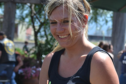 Smiling woman holding a tray of drinks.