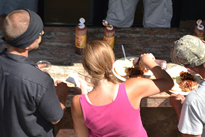 People sitting outside eating barbecue.