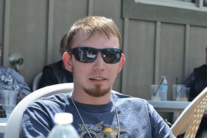 Man wearing dark sunglasses and a Ride for Life shirt.