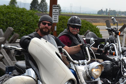 Sitting on their motorcycles.