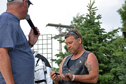 Man on stage speaking into microphone.