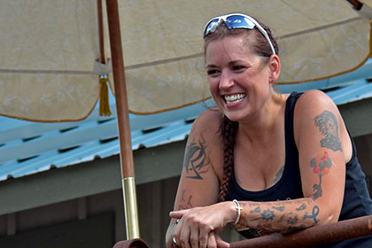 Smiling woman standing outside under an umbrella.