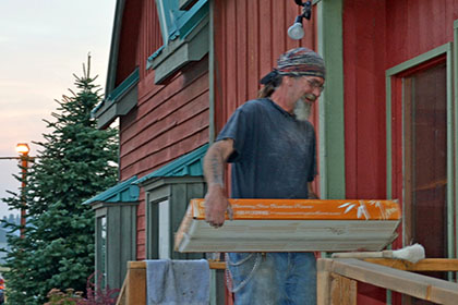 Bearded man holding a box.