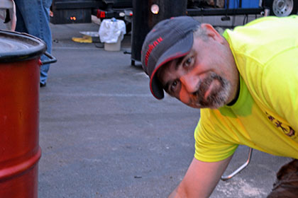 Man wearing a hat looks at the camera.
