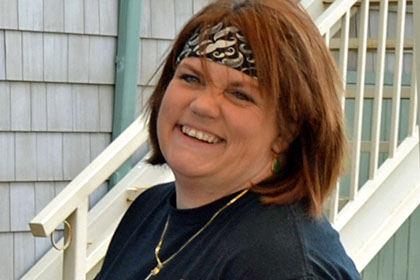 A smiling woman holding her phone.