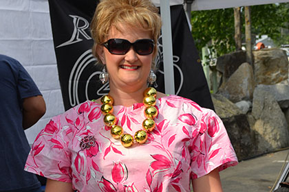 Woman in a dress smiles for the camera.