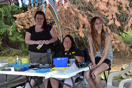 Sitting at a table outside under a tent.