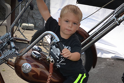 Child sitting on motorcycle.