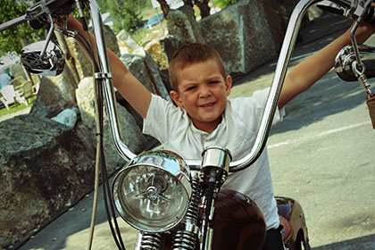 Child sitting on motorcycle.