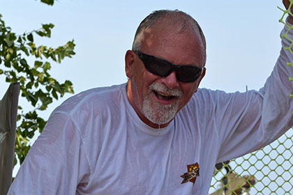 A wet man climbing out of the dunk tank.