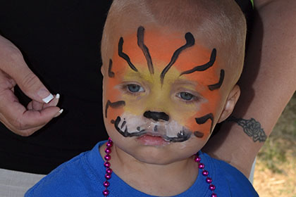 Child with their face painted.