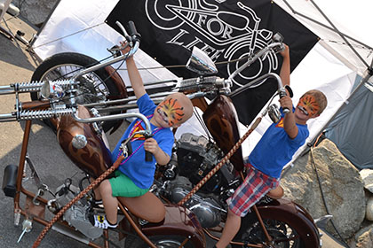 Two kids on the display motorcycles.