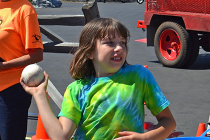 Child getting ready to throw a ball at the dunk tank.