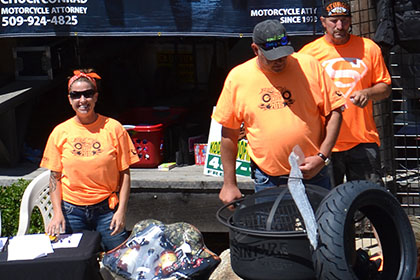 Ride for Life volunteers standing next to raffle and auction items.