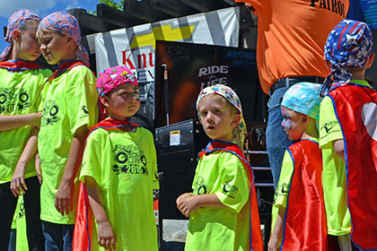 Group of children wearing Ride for Life shirts, capes, and bandanas.