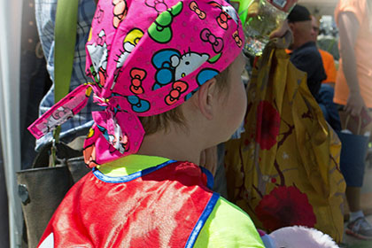 Child wearing cape and bandana.