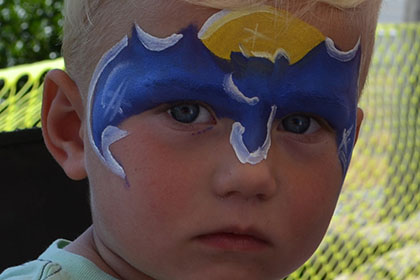 Child with a Batman painted face.