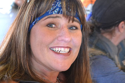 A woman smiling while having her picture taken.